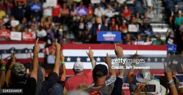 Audience members put their index finger up to symbolize America First while President Donald Trump speaks at a Save America Rally to support...