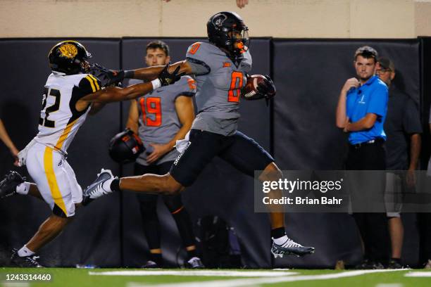 Running back Ollie Gordon II of the Oklahoma State Cowboys stiff arms his way to a 53-yard touchdown against safety Marcus Askew II of the Arkansas...