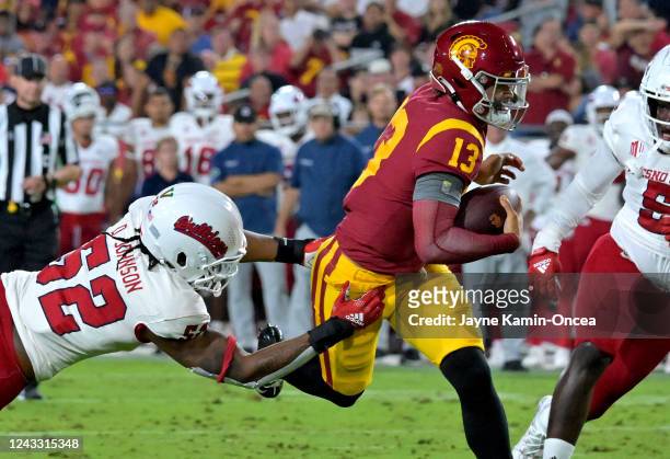 Quarterback Caleb Williams of the USC Trojans breaks away from defensive end Da'Marcus Johnson of the Fresno State Bulldogs and runs into the end...
