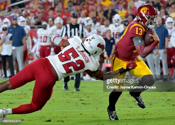 Quarterback Caleb Williams of the USC Trojans breaks away from defensive end Da'Marcus Johnson of the Fresno State Bulldogs and runs into the end...