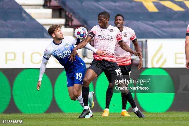 Callum Lang of Wigan Athletic and Tyrese Fornah of Reading FC battle for the ball during the Sky Bet Championship match between Wigan Athletic and...