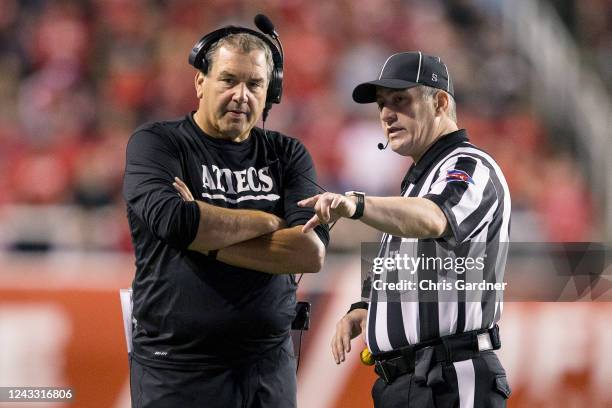 Head coach Brady Hoke of the San Diego State Aztecs talks with head linesman Greg Downum during the first half of their game against the Utah Utes...