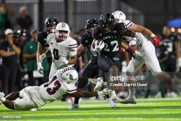 Nasjzaé Bryant-Lelei of the Hawaii Rainbow Warriors runs past a diving CJ Barnes of the Duquesne Dukes during the second half of an NCAA football...