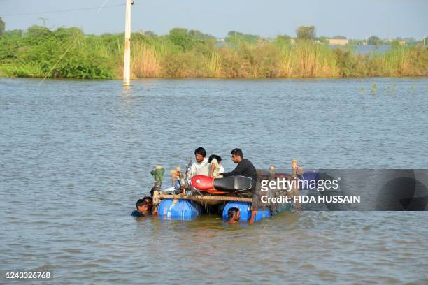 Internally displaced people wade through floodwaters after heavy monsoon rains at Usta Mohammad city in Jaffarabad district of Balochistan province...