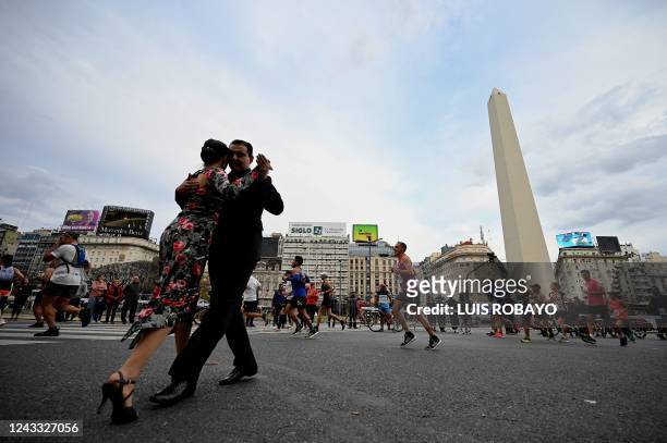 Couple dances tango as runners take part in the Buenos Aires marathon in Buenos Aires, Argentina on September 18, 2022. - The Buenos Aires marathon...