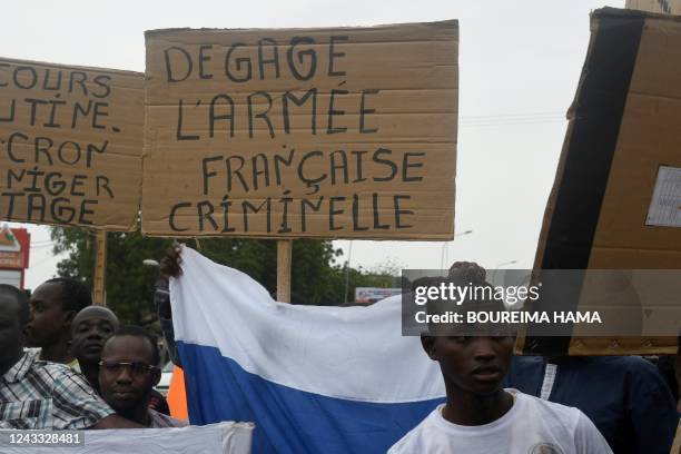 Man holds a placard reading "Clear off criminal French army" as people demonstrate against French military presence in Niger on September 18, 2022 in...