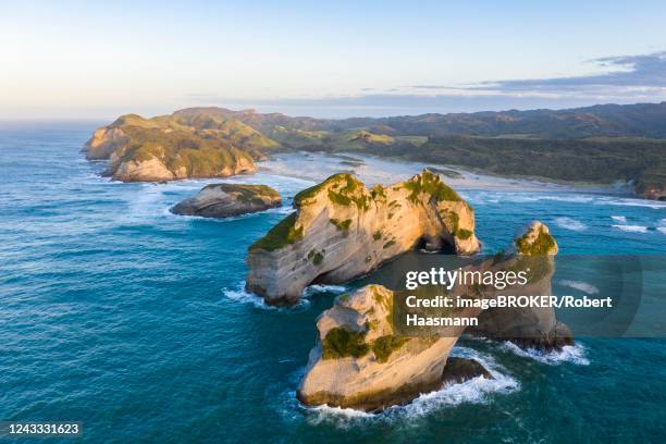 rock island on wharariki beach, wharariki beach, golden bay, southland, new zealand - south island new zealand stock pictures, royalty-free photos & images