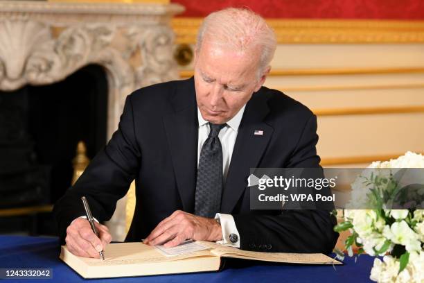 President Joe Biden signs a book of condolence at Lancaster House in London, following the death of Queen Elizabeth II on September 18, 2022 in...