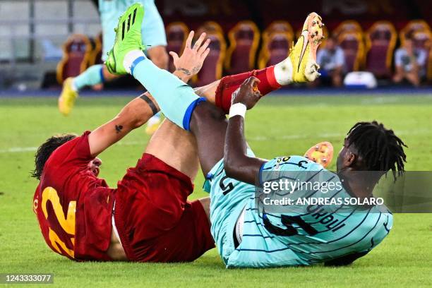 Atalanta's Italian defender Caleb Okoli and AS Roma's Italian midfielder Nicolo Zaniolo fall in the penalty area during the Italian Serie A football...