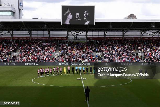 Both teams walk out for a minute silence in memory of HM Queen Elizabeth II during the Premier League match between Brentford FC and Arsenal FC at...