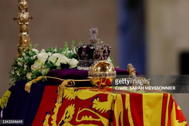 The coffin of Queen Elizabeth II, draped in a Royal Standard and adorned with the Imperial State Crown with the Imperial State Crown and the...
