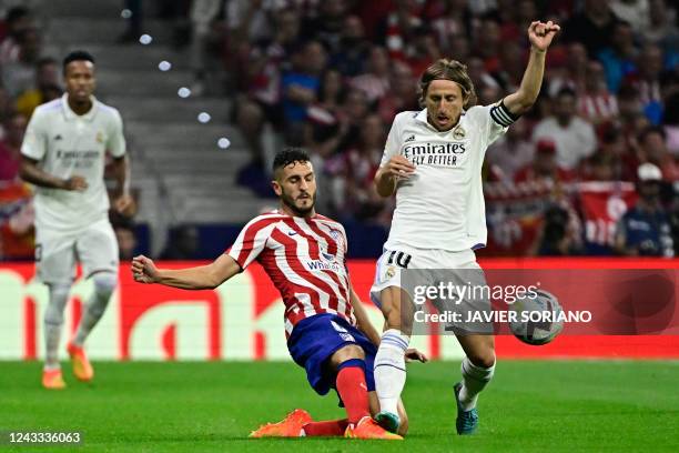 Atletico Madrid's Spanish midfielder Koke fights for the ball with Real Madrid's Croatian midfielder Luka Modric during the Spanish League football...