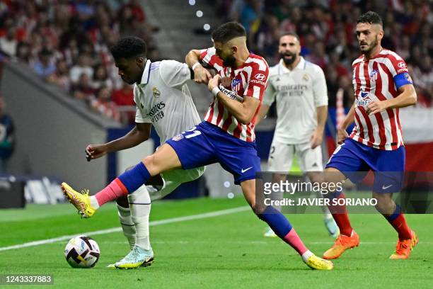 Real Madrid's French defender Aurelien Tchouameni vies with Atletico Madrid's Belgian midfielder Yannick Ferreira-Carrasco during the Spanish League...