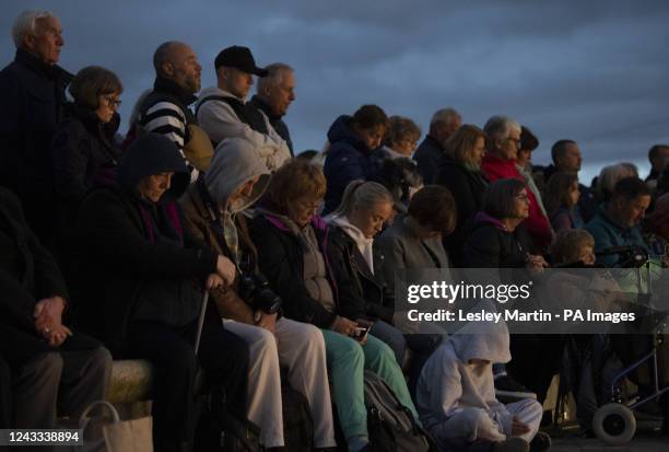 People observe a one minute silence at a service of reflection to honour Queen Elizabeth II at The Kelpies in Falkirk. Picture date: Sunday September...