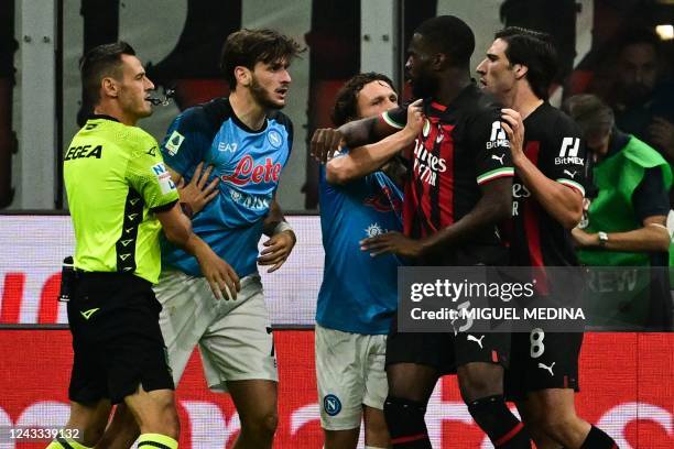 Italian referee Maurizio Mariani holds back Napoli's Georgian forward Khvicha Kvaratskhelia as AC Milan's Italian midfielder Sandro Tonali and...