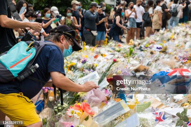 Hong Kong, China, 18 Sept 2022, A man places a Paddington Bear plush on top of the flowers placed in honor of Queen Elisabeth II before the British...