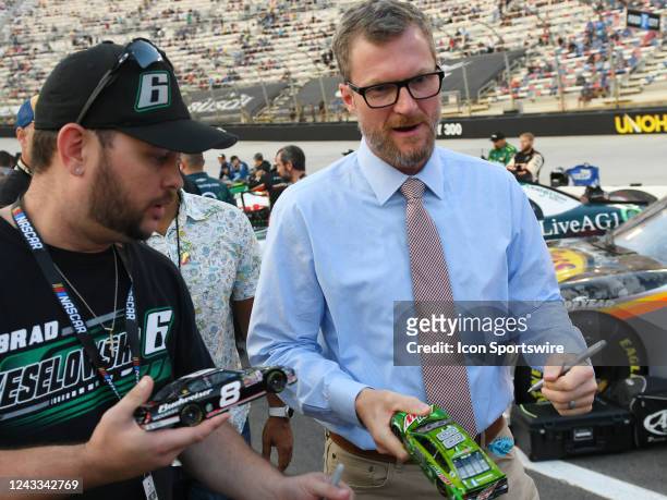 Dale Earnhardt, Jr. Signs an autograph for a fan during pre-race activities before the NASCAR Xfinity Series Food City 300 on September 16, 2022 at...