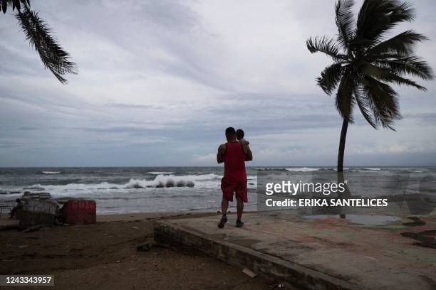 Man with his son is seen on the beach in Nagua, Dominican Republic, on September 18 in the framework of the hurricane Fiona passage through the...