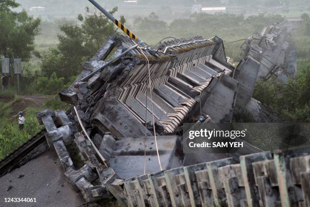 Journalist walks past the collapsed Kaoliao bridge in eastern Taiwan's Hualien county on September 19 following a 6.9 magnitude earthquake on...