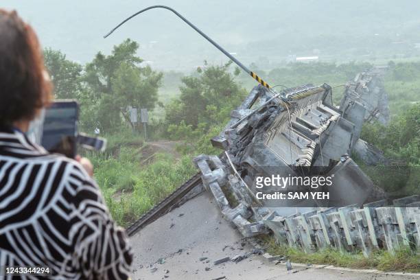 Resident takes photographs of the collapsed Kaoliao bridge in eastern Taiwan's Hualien county on September 19 following a 6.9 magnitude earthquake on...