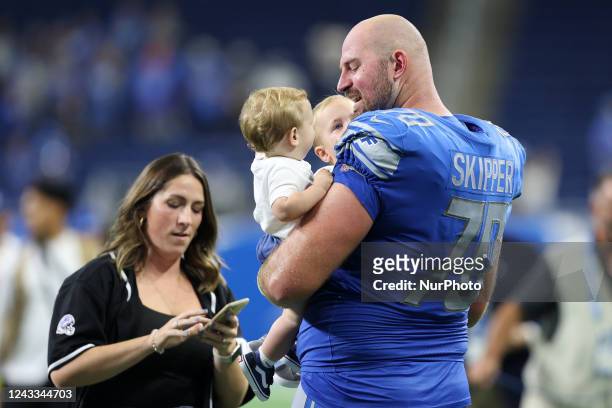 Detroit Lions offensive tackle Dan Skipper holds his two children on the field after an NFL football game between the Washington Commanders and the...