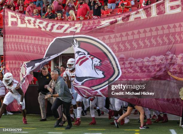 Head coach Mike Norvell of the Florida State Seminoles and team take the field before the game against the Louisville Cardinals at Cardinal Stadium...