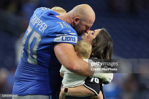 Offensive tackle Dan Skipper of the Detroit Lions kisses his wife while they hold their children on the field after an NFL football game between the...