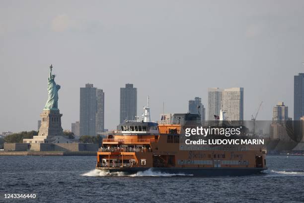 The Statue of Liberty is seen behind a Staten Island ferry in the New York Bay in New York, September 18, 2022.