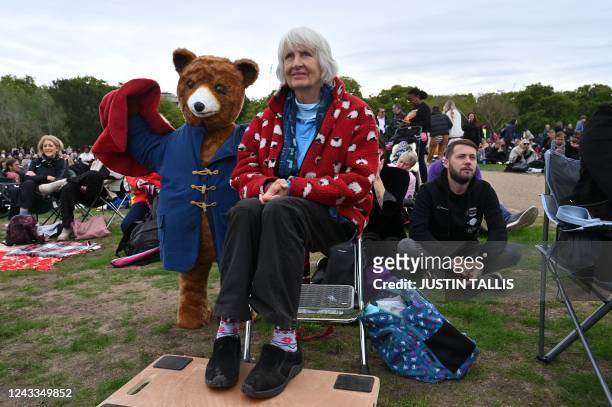 Woman waits with a large Paddington Bear as people gather in Hyde Park where the State Funeral Service of Britain's Queen Elizabeth II will be shown...