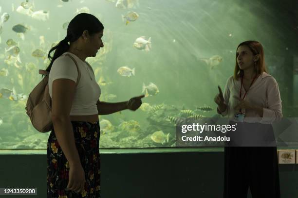 Geraldyne Zapata using sign language visits the explora park aquarium accompanied by Maria Antonia Soto, who works in the park in the accessibility...