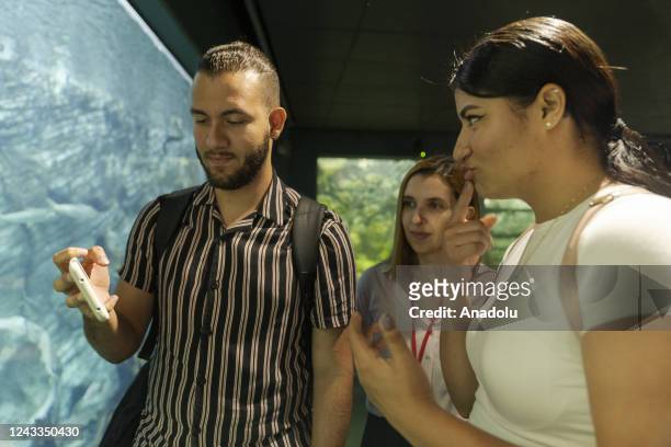 Members of deaf community Sebastian Arenas and Geraldyne Zapata visit the explora park aquarium accompanied by Marian Antonia Soto who works in the...