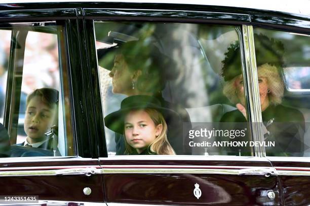 Prince George of Wales, Princess Charlotte of Wales, Catherine, Princess of Wales and Camilla, Queen consort are seen on The Mall ahead of The State...