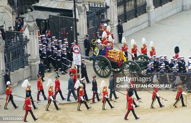 The State Gun Carriage carries the coffin of Queen Elizabeth II, draped in the Royal Standard with the Imperial State Crown and the Sovereign's orb...