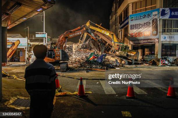 Man oversees a deconstruction of a collapsed building after a 6.8 earthquake hitting Taiwan caused severe damages to buildings, bridges and different...