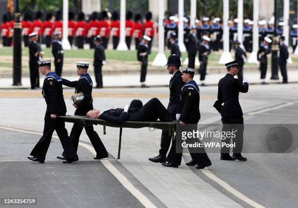 Policeman who had fainted is carried on a stretcher during the State Funeral of Queen Elizabeth II at Westminster Abbey on September 19, 2022 in...