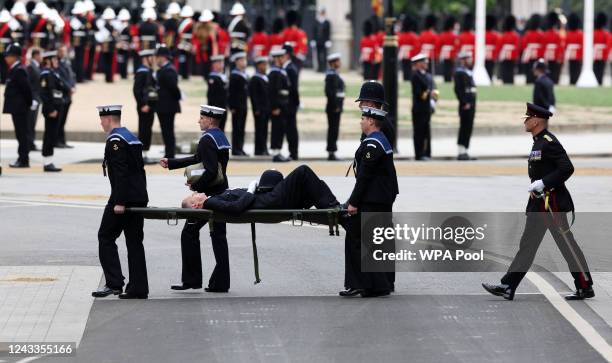 Policeman who had fainted is carried on a stretcher during the State Funeral of Queen Elizabeth II at Westminster Abbey on September 19, 2022 in...