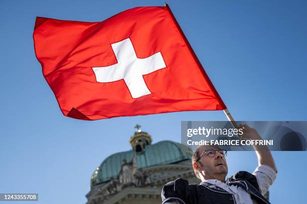 Flag thrower performs with a Swiss flag in front of the Swiss House of Parliament during an event marking the 125th anniversary of the Swiss Farmers'...