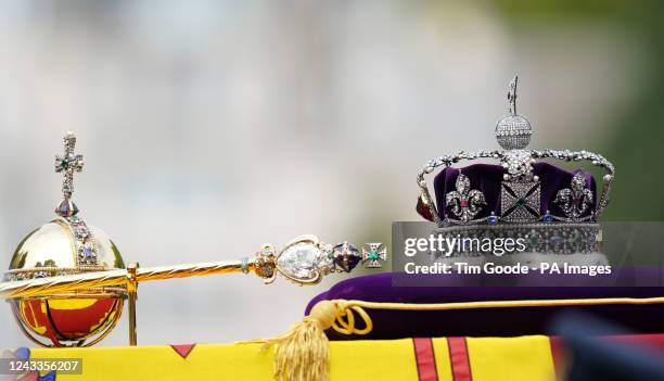 The State Gun Carriage carries the coffin of Queen Elizabeth II, draped in the Royal Standard with the Imperial State Crown and the Sovereign's orb...