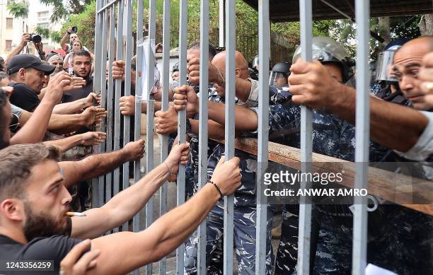Protesters try to pull out the gate leading to the Justice Palace in Lebanon's capital Beirut on September 19 demanding the release of two people...