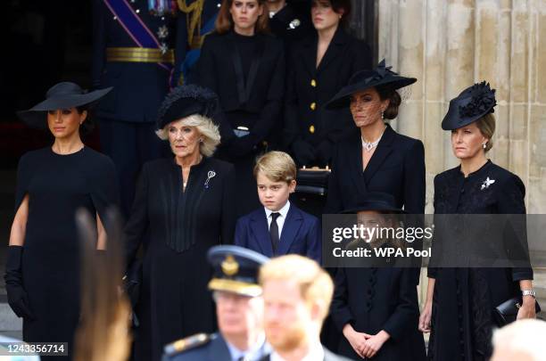 Meghan, Duchess of Sussex, Queen Camilla, Prince George, Princess Charlotte, Catherine, Princess of Wales, and Sophie, Countess of Wessex stand...