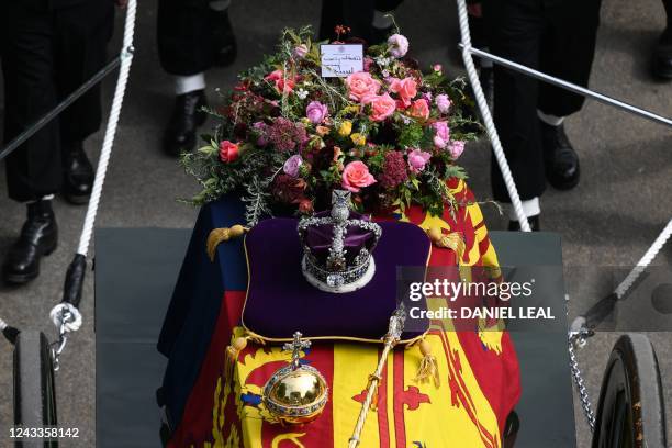 Note from Britain's King Charles III is seen with flowers on the coffin of Queen Elizabeth II, draped in the Royal Standard, on the State Gun...