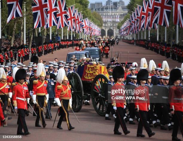 The Queen's funeral cortege borne on the State Gun Carriage of the Royal Navy travels along The Mall with the Gentlemen at Arms on September 19, 2022...