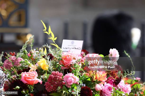 Flowers are seen on the coffin of Queen Elizabeth II as it is carried in a procession after a service at Westminster Abbey on September 19, 2022 in...