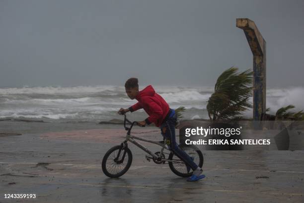 Youth rides his bycicle at the seaside in Nagua, Dominican Republic, on September 19 as Hurricane Fiona passes through the country. - Hurricane Fiona...