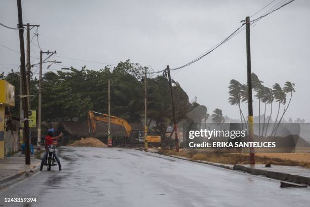 Man takes pictures as palm trees blow in the wind in Nagua, Dominican Republic, on September 19 during the passage of Hurricane Fiona. - Hurricane...