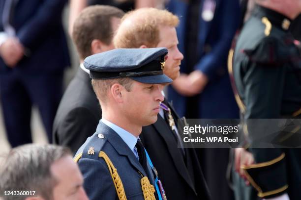 Prince William, Prince of Wales and Prince Harry, Duke of Sussex walk behind the coffin of Queen Elizabeth II being pulled past Buckingham Palace...