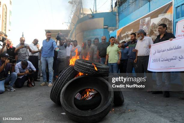 Palestinian protesters burn tires during a demonstration outside the Gaza City headquarters of the United Nations Relief and Works Agency for...