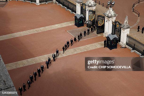 Buckingham Palace household staff return through the gates of Buckingham Palace after paying their respects during the State Funeral of Britain's...