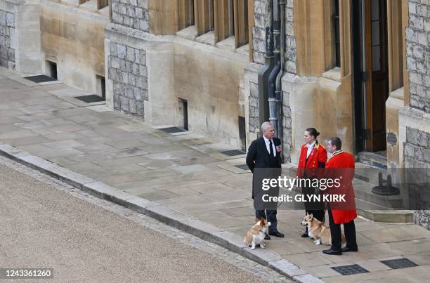 Britain's Prince Andrew, Duke of York stands with the Queen's corgis, Muick and Sandy inside Windsor Castle on September 19 ahead of the Committal...