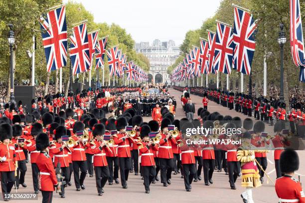 The State Gun Carriage carries the coffin of Queen Elizabeth II, draped in the Royal Standard with the Imperial State Crown and the Sovereign's orb...